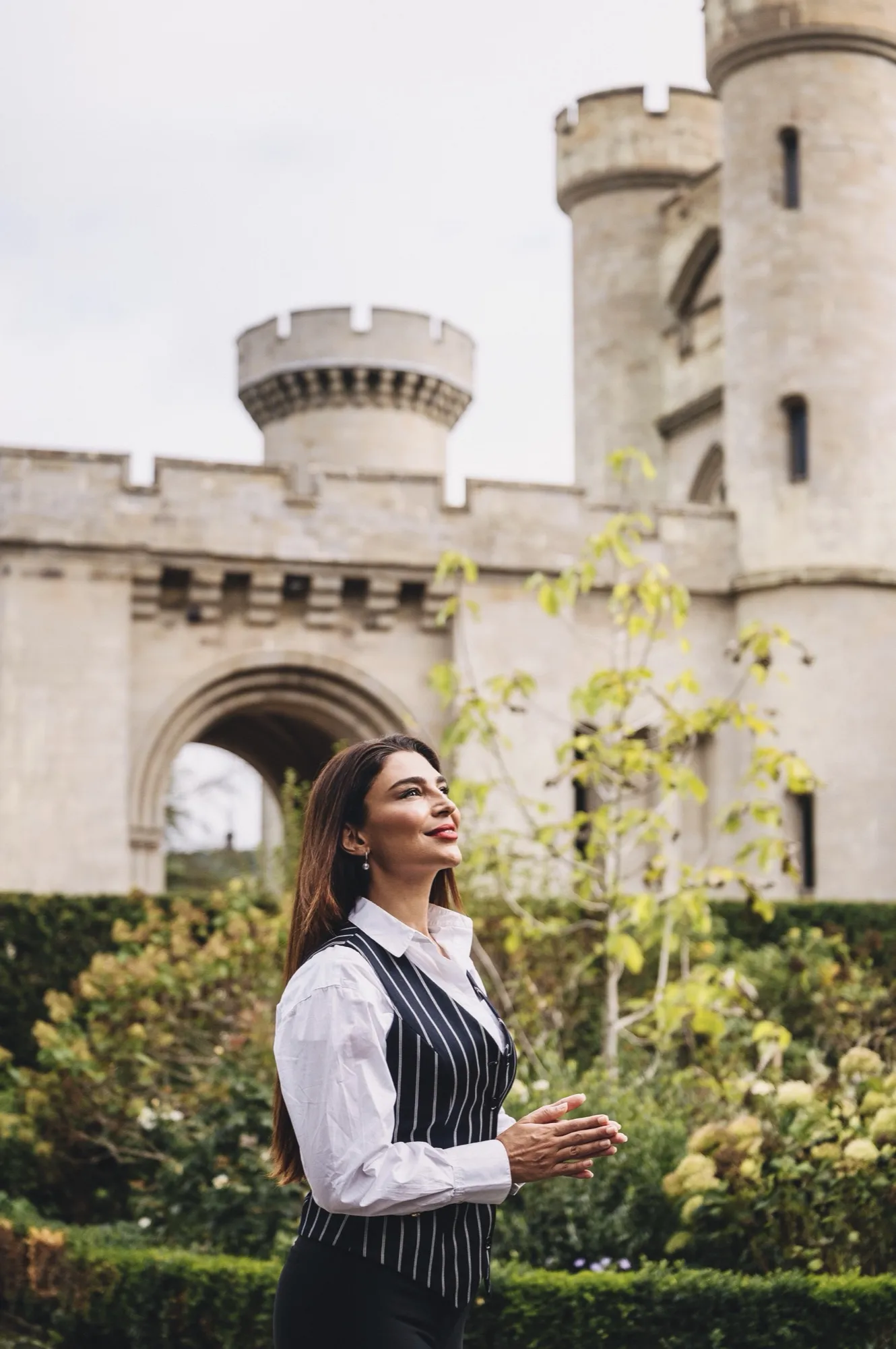 Handan Darici in the gardens below a castle tower